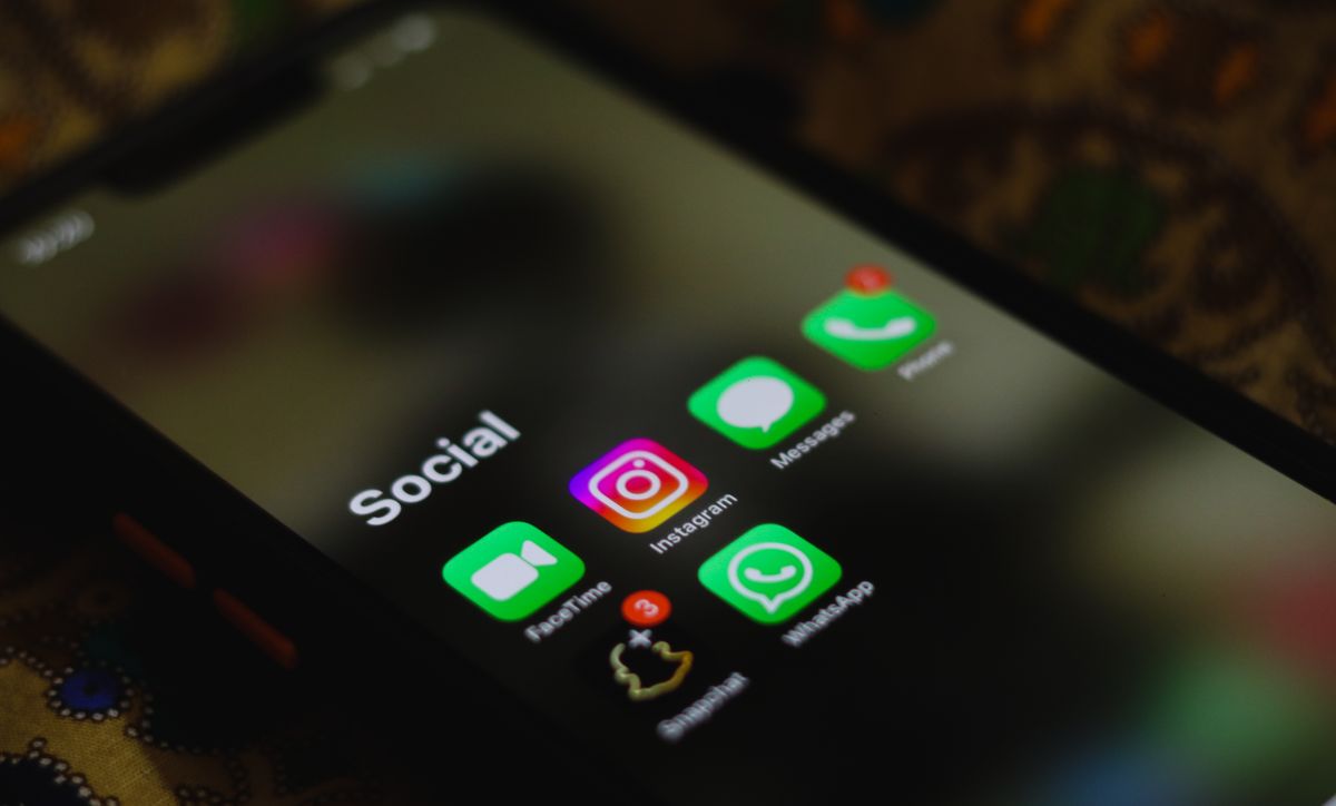 Layar smartphone menampilkan folder aplikasi sosial media Instagram dan WhatsApp