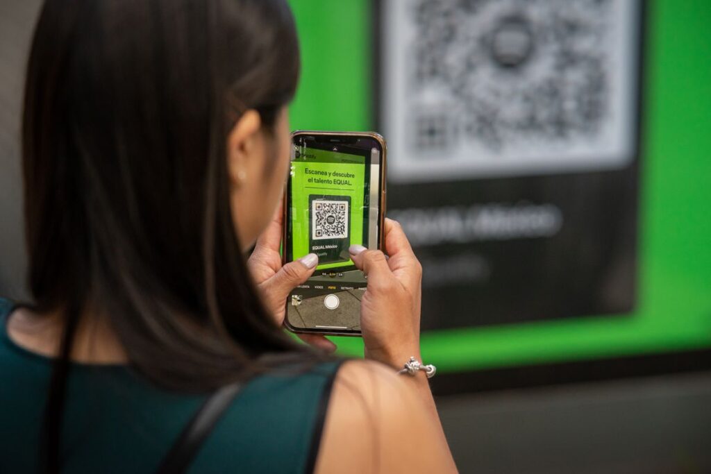 Perempuan scan QR Code branded pakai smartphone