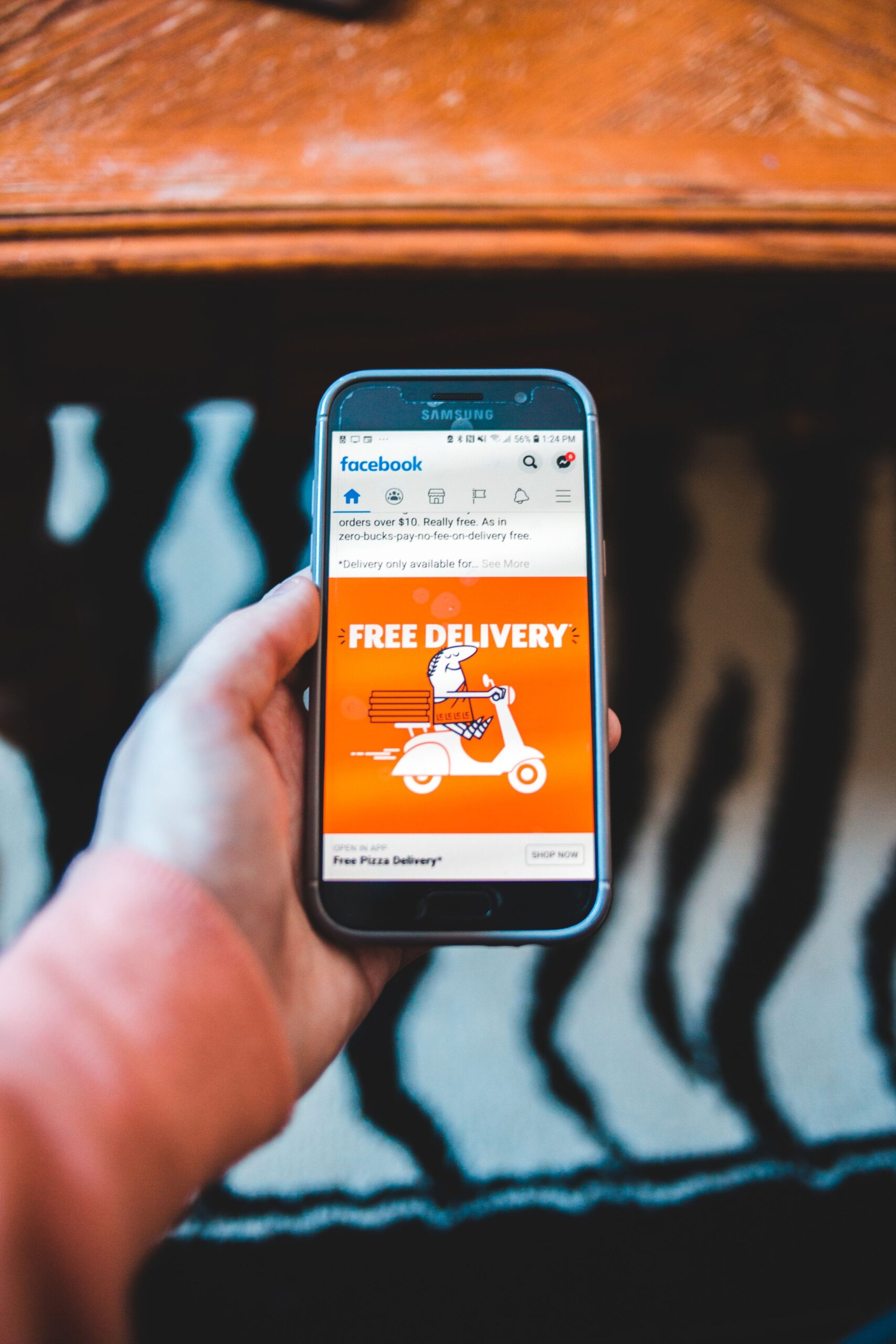 Smartphone menampilkan iklan Facebook, ilustrasi Advantage+ Creative Enhancements di Meta Ads